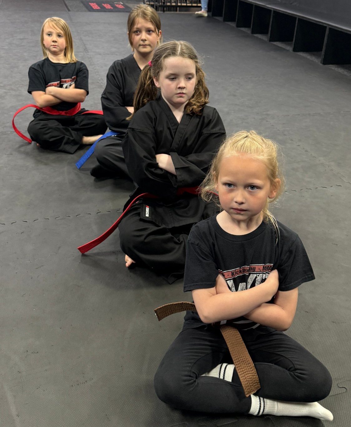 Girls sitting in line in a kids karate class at EWF Martial Arts